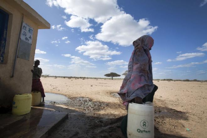 Oxfam is working with a local partner, the Horn of Africa Voluntary Youth Committee (HAVOYOCO) to help agro-pastoralist communities prepare for and cope with drought by improving access to water resources and pasture, and improving livestock health. A woman is carrying an Oxfam bucket. Photo credit: Petterik Wiggers.