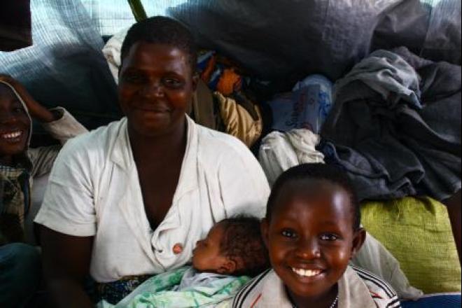 Tereza avec deux de ses enfants dans son abri de fortune. Le plus jeune n’avait que deux jours quand une attaque des rebelles les a jetés sur les routes et contraints à passer en Ouganda. Photo : Grace Cahill/Oxfam Tereza et ses deux enfants