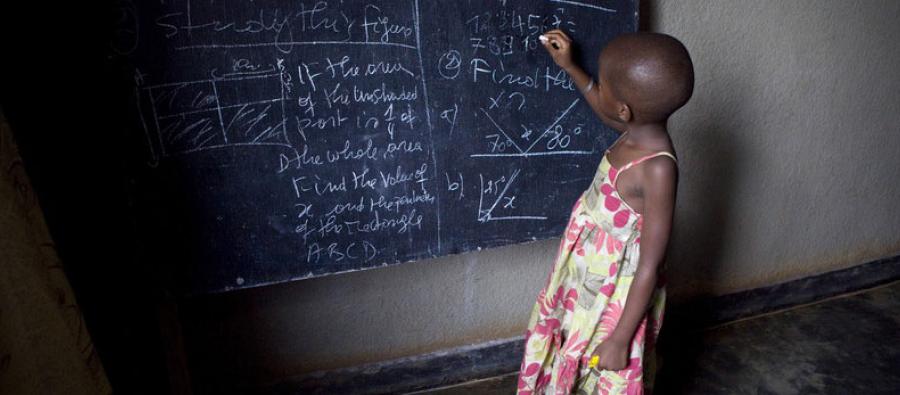 Ecolière devant un tableau noir dans une salle de classe de Kigali, Rwanda. Photo : Simon Rawles