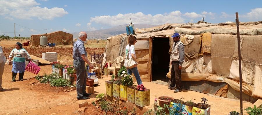 A refugee family, who do not wish to be named, stand with Oxfam staff outside their temporary home in an informal settlement, Bekaa Valley, Lebanon A refugee family stand outside their temporary home in an informal settlement, Bekaa Valley, Lebanon