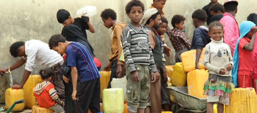 Displaced children in Yemen wait together and collect water Displaced children in Yemen wait and collect Water