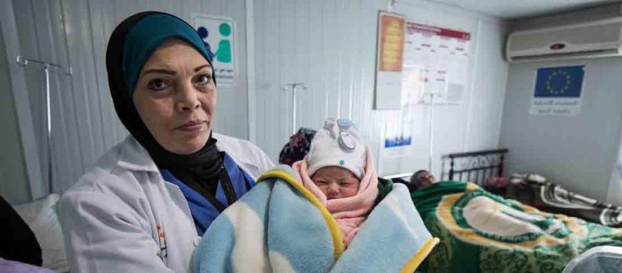 A doctor holds a baby in the maternity center in Za’atari refugee camp, Jordan. A doctor holds a new born baby, Za'atari Refugee Camp, Jordan