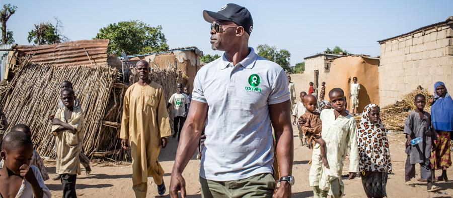 Djimon Hounsou camina por una calle de Jakana, Nigeria, que conduce a uno de los campos para personas desplazadas. Djimon Hounsou camina por una calle de Jakana, Nigeria, que conduce a uno de los campos para personas desplazadas.