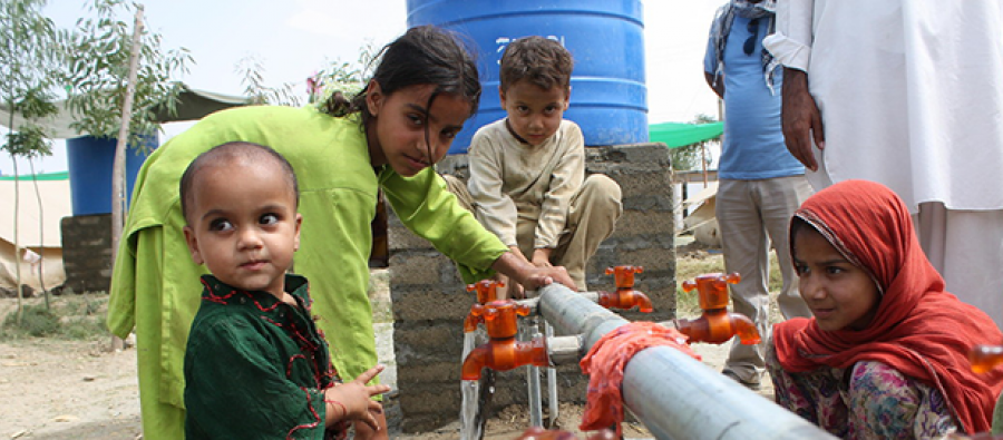 Children washing their plates at an Oxfam water point, Swat valley, Pakistan