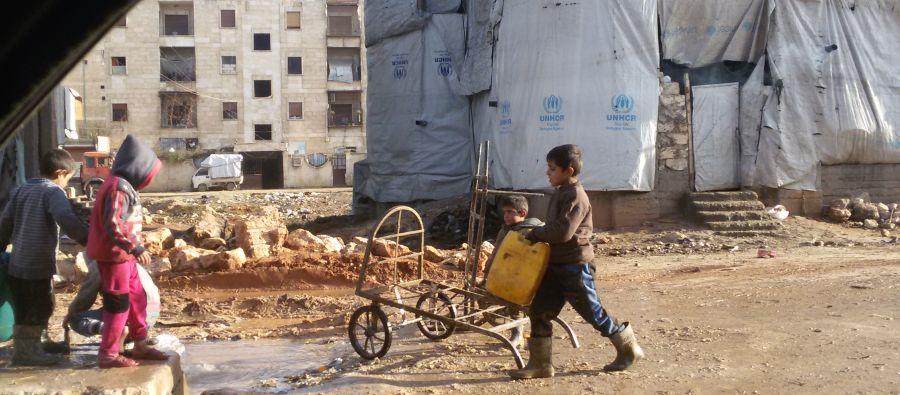 Des enfants remplissent des bidons à un point d’eau public dans le quartier de Tishreen, à Alep-Ouest. Beaucoup sont des déplacés qui vivent dans des bâtiments en construction sans eau courante ni sanitaires. Des enfants remplissent des bidons à un point d’eau public dans le quartier de Tishreen, à Alep-Ouest. Beaucoup sont des déplacés qui vivent dans des bâtiments en construction sans eau courante ni sanitaires.