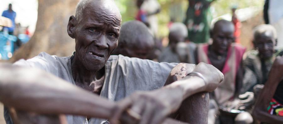 Majok esperando la distribución de alimentos del Programa Mundial de Alimentos en Nyal. Ayudado por sus familiares, tuvo que caminar durante hora y media desde su casa para estar presente físicamente en el registro. Foto: Bruno Bierrenbach Feder/Oxfam Majok esperando la distribución de alimentos del Programa Mundial de Alimentos en Nyal. Ayudado por sus familiares, tuvo que caminar durante hora y media desde su casa para estar presente físicamente en el registro. Foto: Bruno Bierrenbach Feder/Oxfam