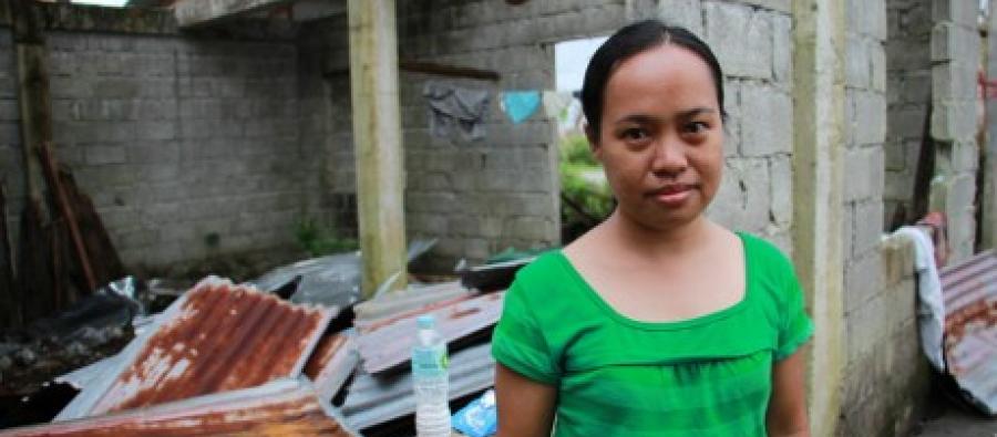 Rowena enfrente de su casa destruida en Catigbian, Tanauan Rowena enfrente de su casa destruida. Foto: Anne Wright / Oxfam