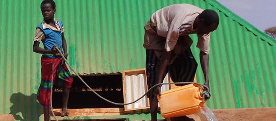 Abdi Ahmed Jamaa with one of his children fetching water from a rehabilitated water cistern (barkad). Photo TARDO/Oxfam Abdi Ahmed Jamaa with one of his children fetching water from a rehabilitated water cistern (barkad). Photo TARDO/Oxfam