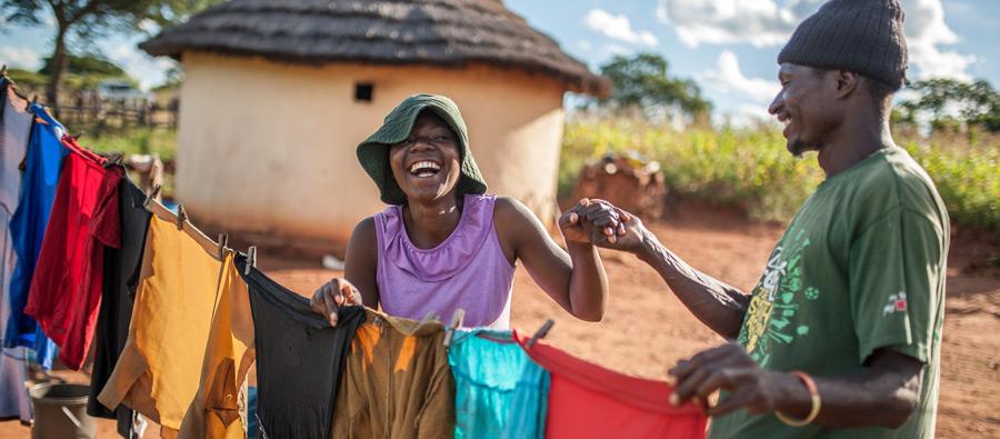 Ulita Mutambo’s husband Muchineripi Sibanda helps her hang up laundry outside their home in Ture Village, Zvishevane region, Zimbabwe. Aurelie Marrier d'Unienville / Oxfam Ulita Mutambo’s husband Muchineripi Sibanda helps her hang up laundry outside their home in Ture Village, Zvishevane region, Zimbabwe. Aurelie Marrier d'Unienville / Oxfam