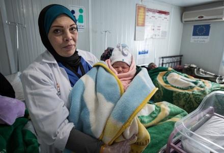 A doctor holds a new born baby in a maternity centre in Za'atari refugee camp, Jordan A doctor holds a new born baby in Za'atari camp, Jordan