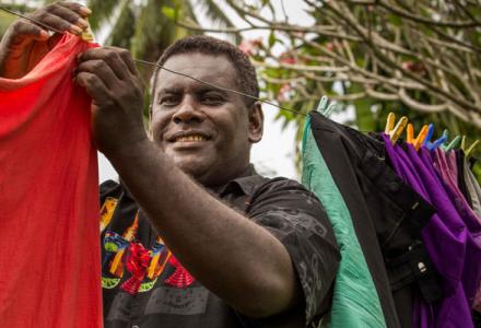 Solomon Island. Man hunging clothes on the line